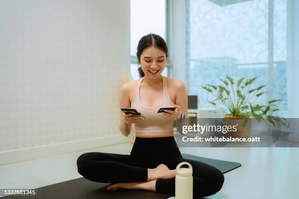 woman using smart phone buying sport equipment at home. - sportswear shopping stockfoto's en -beelden