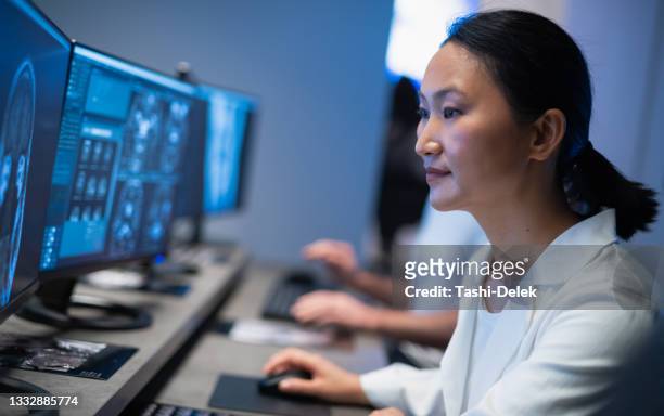 médicos que trabajan con computadoras y analizan escaneos médicos - radiologist fotografías e imágenes de stock