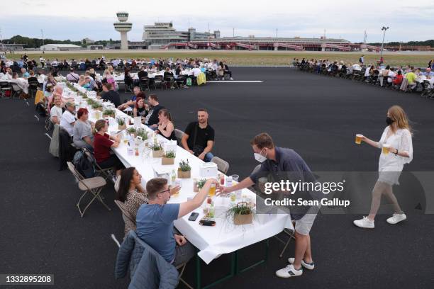 People attend the "Freedom Dinner" on the runway at former Tegel Airport on August 07, 2021 in Berlin, Germany. Sponsored by the city, the event with...