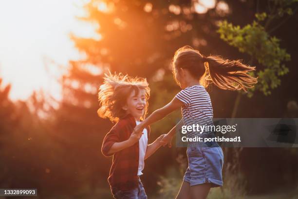 un garçon et une fille jouant dehors - pureté photos et images de collection