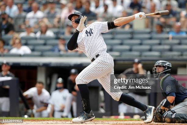 Aaron Judge of the New York Yankees follows through on his first inning home run against the Seattle Mariners at Yankee Stadium on August 07, 2021 in...