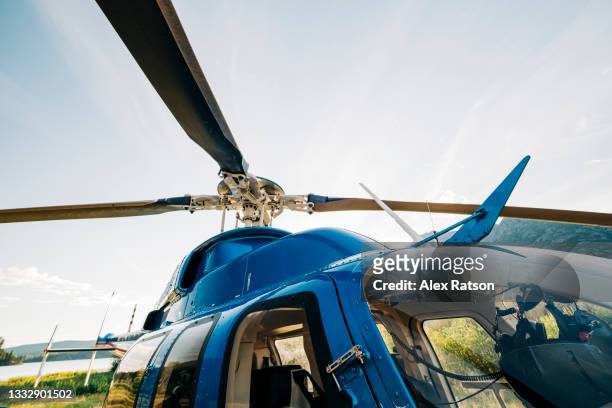 looking up at the main rotor of a bell 407 gxi helicopter on a sunny day - helicopter cockpit stock pictures, royalty-free photos & images