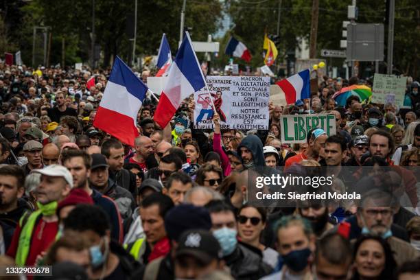 Protesters march against France's coronavirus disease safety restrictions on August 7, 2021 in Paris, France. The new health bill makes inoculation...