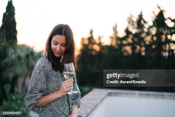 young woman enjoys a glass of prosecco on rooftop terrace - prosecco stock pictures, royalty-free photos & images