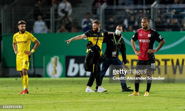 Streaker is seen next to Antonios Papdopoulos of Dortmund and Kevin Lankford of Wiesbaden during the DFB Cup first round match between SV Wehen...