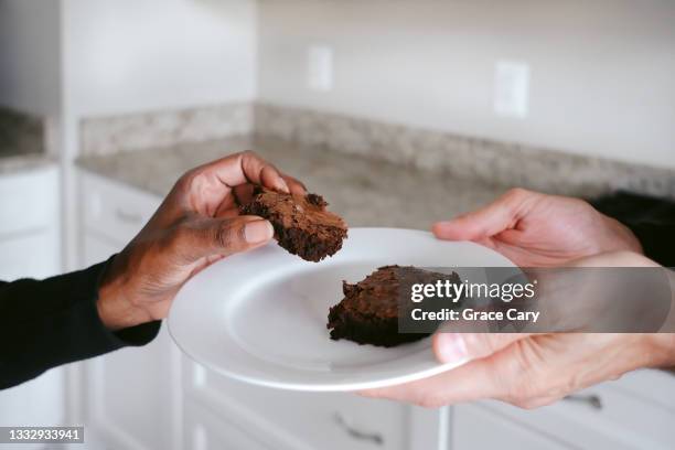 man offers woman fudge brownie - white fudge stock pictures, royalty-free photos & images