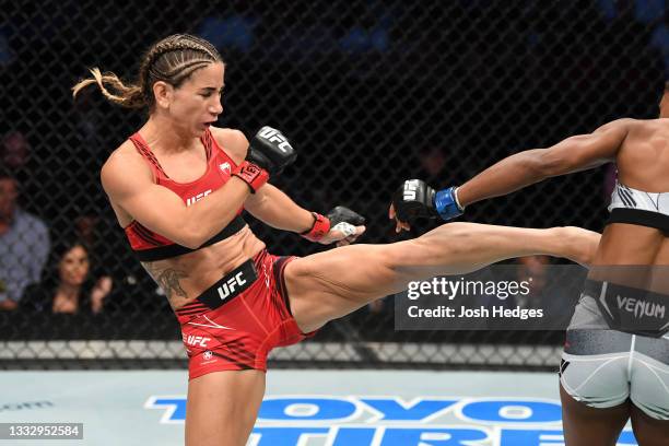 Tecia Torres kicks Angela Hill in their women's strawweight bout during the UFC 265 event at Toyota Center on August 07, 2021 in Houston, Texas.