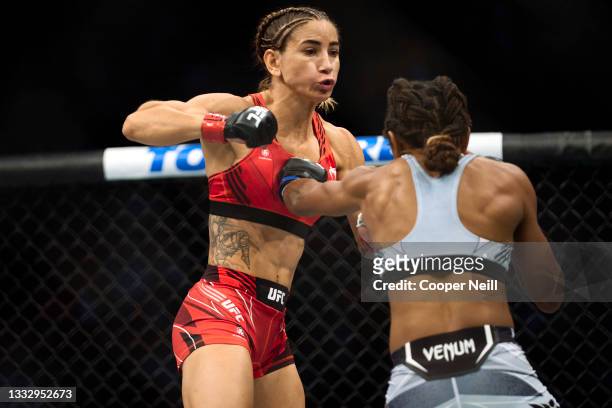 Tecia Torres punches Angela Hill in their women's strawweight bout during the UFC 265 event at Toyota Center on August 07, 2021 in Houston, Texas.