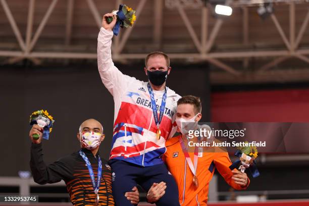 Silver medalist Mohd Azizulhasni Awang of Team Malaysia and bronze medalist Harrie Lavreysen of Team Netherlands lift on their shoulders a gold...