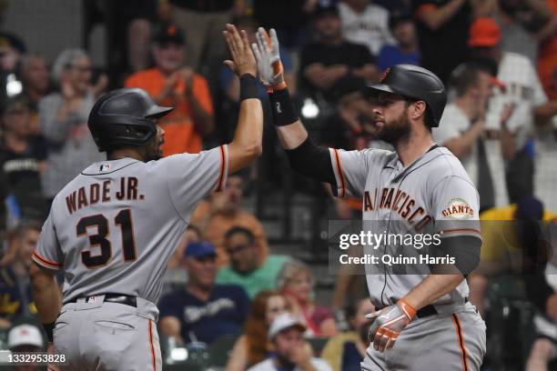 LaMonte Wade Jr and Brandon Belt of the San Francisco Giants celebrate after the two-run home run in the 11th inning against the Milwaukee Brewers at...