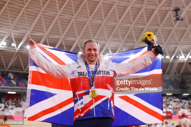 Gold medalist Jason Kenny of Team Great Britain, poses on the podium while holding the flag of his country during the medal ceremony after the Men's...