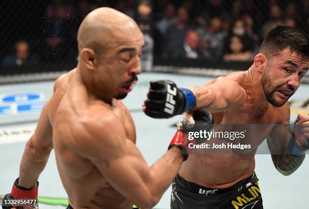 Pedro Munhoz of Brazil punches Jose Aldo of Brazil in their bantamweight bout during the UFC 265 event at Toyota Center on August 07, 2021 in...