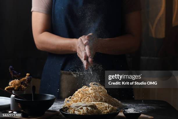 hands of woman make an egg noodle on the black table - gesture photos et images de collection