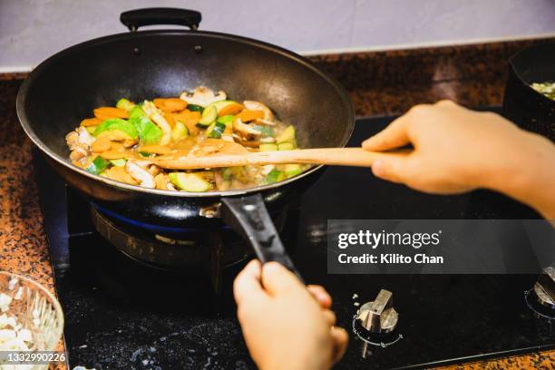 personal perspective of cooking stir-fried vegetables - roerbakken stockfoto's en -beelden