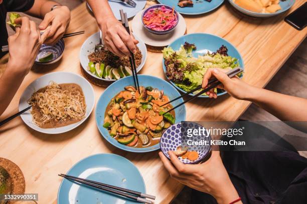 friends enjoying dinner together - chinese family dinner stock pictures, royalty-free photos & images