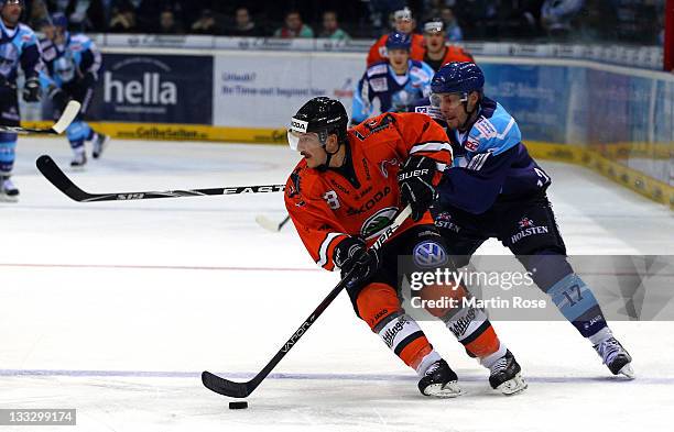 Thomas Oppenheimer of Hamburg battles for the puck with Robert Bina of Wolfsburg during the DEL match between Hamburg Freezers and Grizzly Adams at...