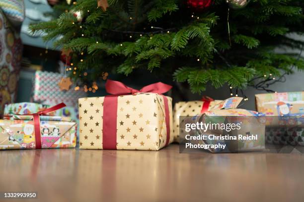 many christmas presents under wonderful christmas tree - bajo fotografías e imágenes de stock