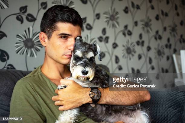 young depressed man embracing his dog at home - scared dog stock pictures, royalty-free photos & images