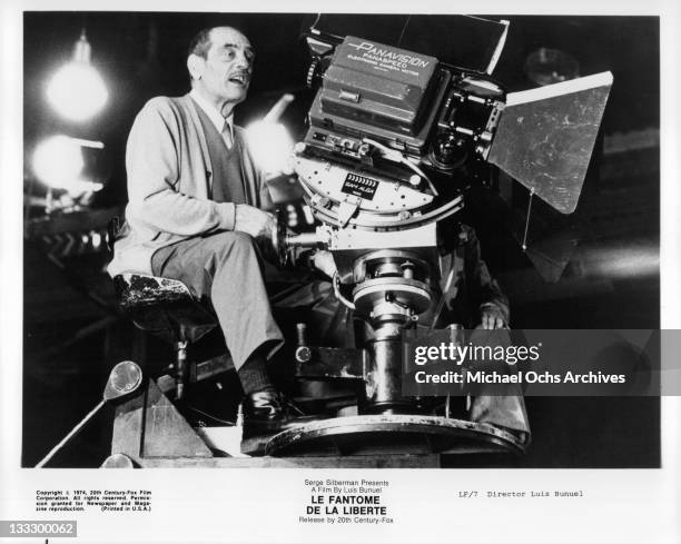 Director Luis Bunuel sitting with camera on the set of the film 'Le Fantome De La Liberte', 1974.