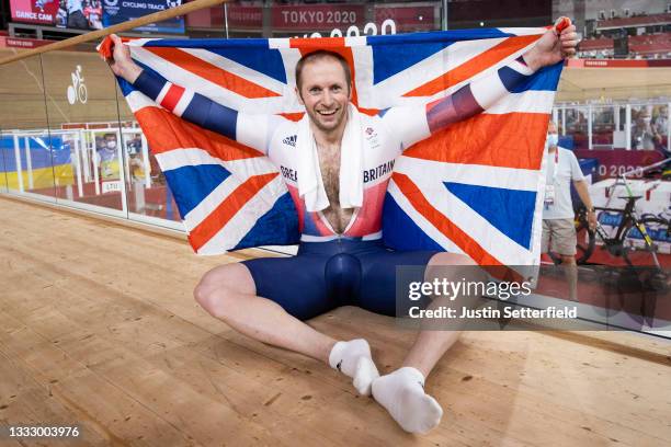 Jason Kenny of Team Great Britain celebrates winning the gold medal while holding the flag of his country during the Men's Keirin final, 1/6th place...