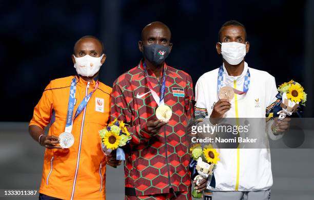 Silver medalist Abdi Nageeye of Team Netherlands, gold medalist Eliud Kipchoge of Team Kenya and bronze medalist Bashir Abdi of Team Belgium pose...