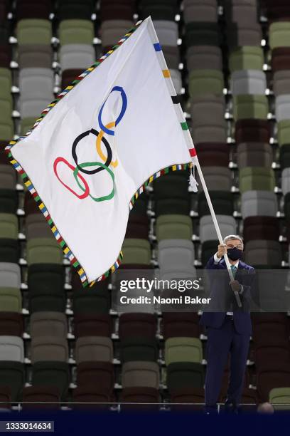 President of the International Olympic Committee, Thomas Bach waves the Olympic Flag during the Closing Ceremony of the Tokyo 2020 Olympic Games at...