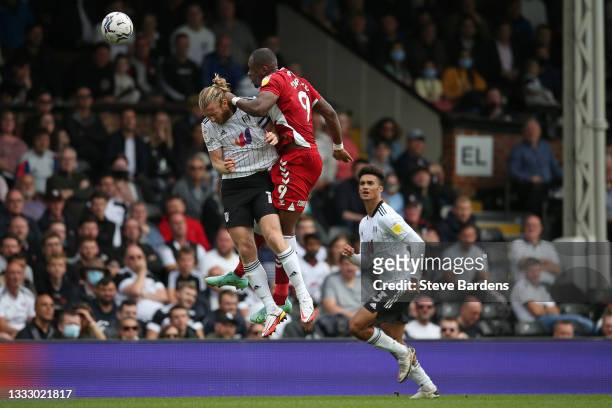 Tim Ream of Fulham is caught by Uche Ikpeazu of Middlesbrough during a challenge for a header during the Sky Bet Championship match between Fulham...