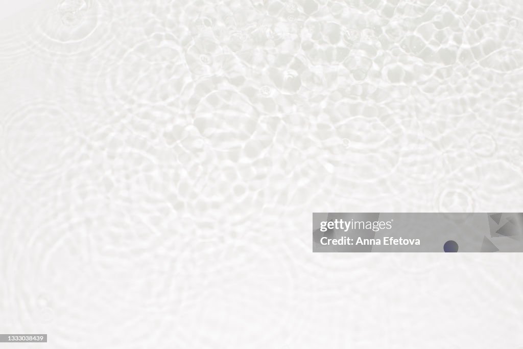 A transparent water with waves and light reflections on bottom. Top view