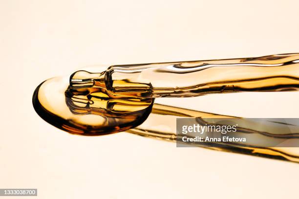 cbd oil in glass pipette on luxury gold reflective surface. organic cosmetic product for face care. front view and macro photography - cannabinoid fotografías e imágenes de stock