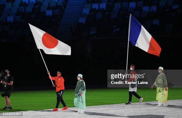 Flag bearer Ryo Kiyuna of Team Japan and Steven Da Costa of Team France during the Closing Ceremony of the Tokyo 2020 Olympic Games at Olympic...