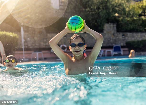 kids playing ball in swimming pool - candid volleyball stock pictures, royalty-free photos & images