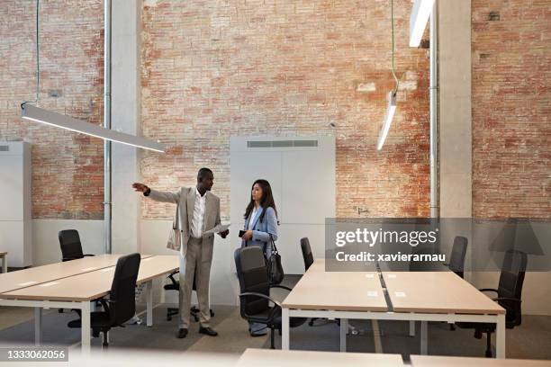 commercial real estate broker showing property to client - commercial real estate stock pictures, royalty-free photos & images