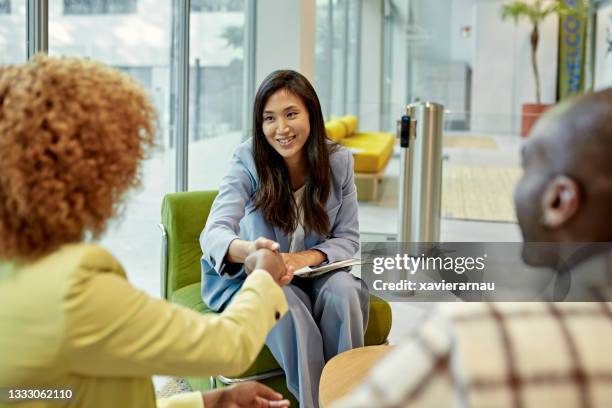 asian real estate agent congratulating clients at closing - contrato de arrendamento imagens e fotografias de stock