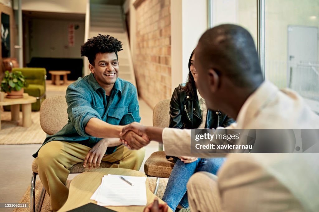 Happy Client Shaking Hands with Real Estate Agent at Closing