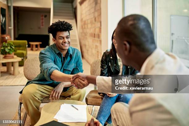 happy client shaking hands with real estate agent at closing - commercial real estate agent stock pictures, royalty-free photos & images
