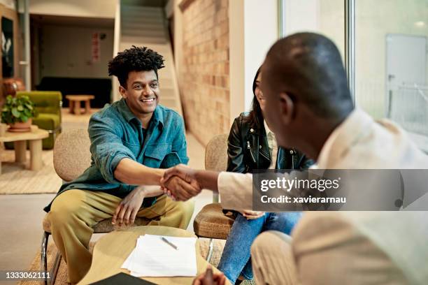 happy client shaking hands with real estate agent at closing - contrato de arrendamento imagens e fotografias de stock