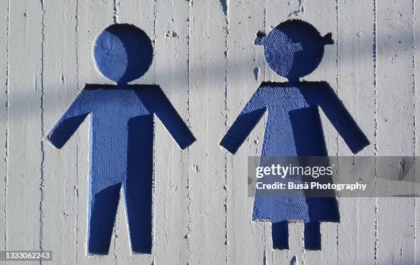 male and female icons carved in concrete and painted in blue color - role reversal stock pictures, royalty-free photos & images