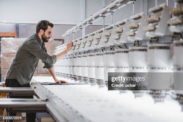 mann arbeitet in textil-stickmaschine - textilfabrik stock-fotos und bilder