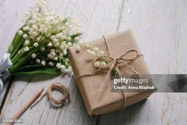 lily-of-the-valley spring white flowers on pastel blue background, pencil and empty paper card with envelope with copy space. - lily of the valley stock pictures, royalty-free photos & images