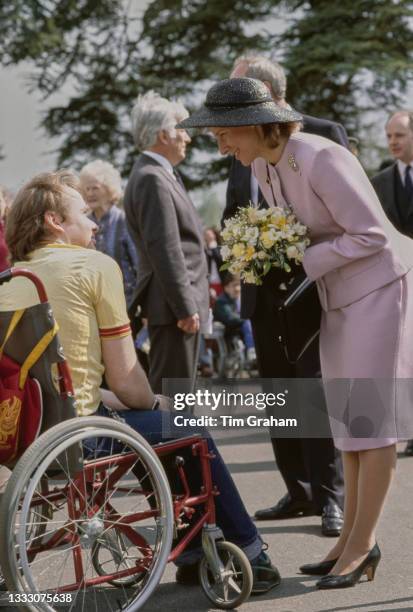 Danish member of the British Royal Family Birgitte, Duchess of Gloucester, wearing a pale pink outfit and a black wide-brim hat, holding a bouquet of...
