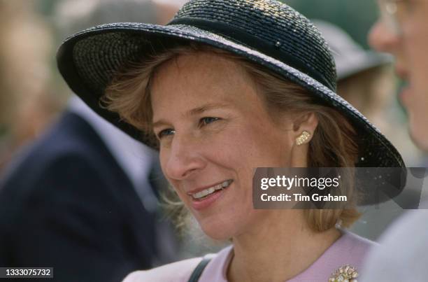 Danish member of the British Royal Family Birgitte, Duchess of Gloucester, wearing a pale pink outfit and a black wide-brim hat, smiles during a...