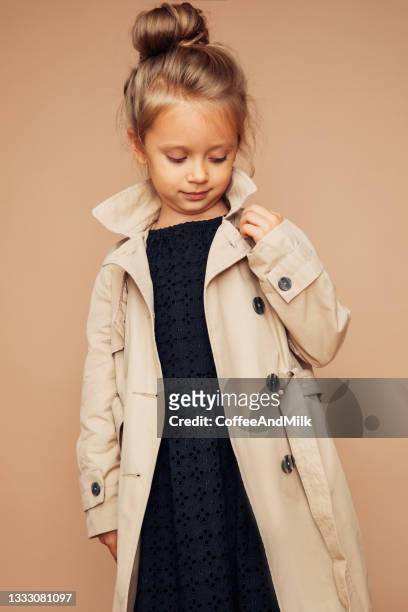 portrait of cute girl at the studio - beige jas stockfoto's en -beelden