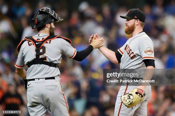 Curt Casali and Zack Littell of the San Francisco Giants celebrate after defeating the Milwaukee Brewers 5-4 at American Family Field on August 08,...