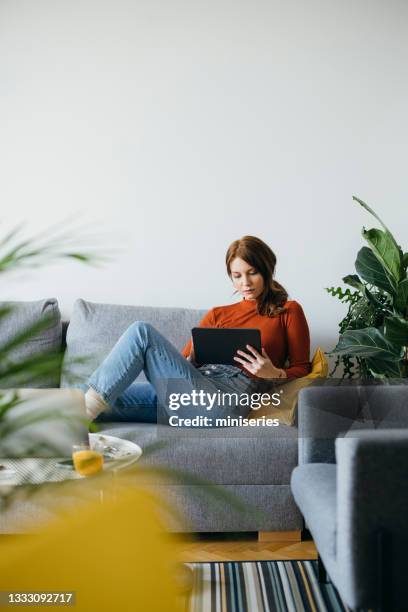 beautiful woman using digital tablet at home - reading ipad stock pictures, royalty-free photos & images