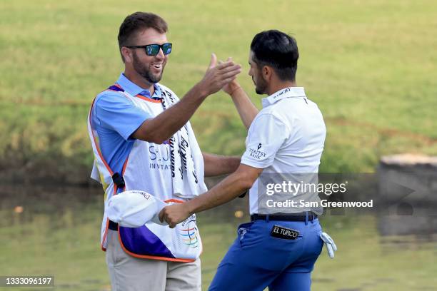 Abraham Ancer of Mexico and his caddie celebrate after winning the FedEx St. Jude Invitational after the second playoff hole at TPC Southwind on...