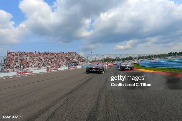 Brad Keselowski, driver of the Wabash National Ford, and Joey Logano, driver of the Verizon 5G Ford, lead the field on a pace lap prior to the NASCAR...