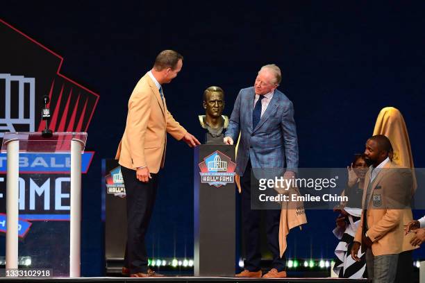 Peyton Manning unveils his bust with his father Archie Manning during the NFL Hall of Fame Enshrinement Ceremony at Tom Benson Hall Of Fame Stadium...