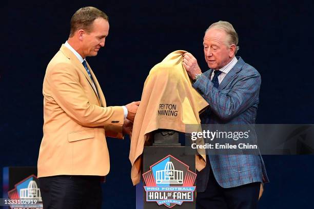Peyton Manning unveils his bust with his father Archie Manning during the NFL Hall of Fame Enshrinement Ceremony at Tom Benson Hall Of Fame Stadium...