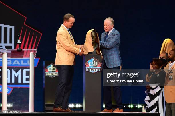 Peyton Manning unveils his bust with his father Archie Manning during the NFL Hall of Fame Enshrinement Ceremony at Tom Benson Hall Of Fame Stadium...