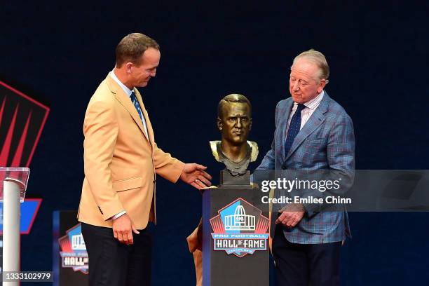 Peyton Manning unveils his bust with his father Archie Manning during the NFL Hall of Fame Enshrinement Ceremony at Tom Benson Hall Of Fame Stadium...